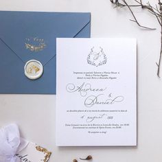 the wedding stationery is laid out on top of an envelope and some other items