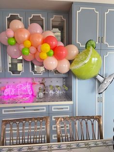 balloons are floating in the air above a kitchen table