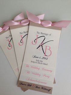 three wedding programs with pink bows on them