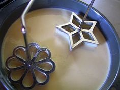 two pieces of metal sitting on top of liquid in a bowl