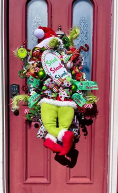 a christmas wreath on the front door of a house with candy canes and other decorations