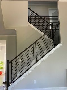 a stair case in the middle of a living room with an open door on one side