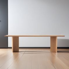 a wooden table sitting on top of a hard wood floor next to a white wall