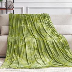 a green blanket sitting on top of a couch