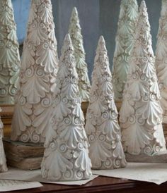 several white ceramic trees sitting on top of a table next to each other in front of a mirror