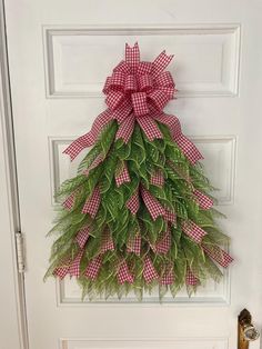 a door decorated with a red and white checkered christmas tree hanging on the front door