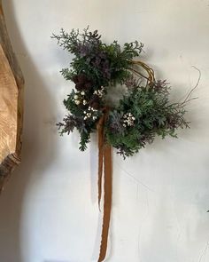 a wreath hanging on the wall next to a piece of wood