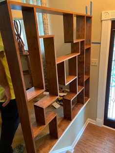 a man standing in front of a book shelf filled with lots of wooden shelves and drawers