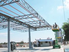 two men are standing on the roof of a building that is being constructed into a structure