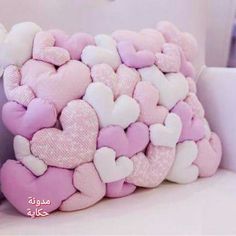 a pink and white pillow with hearts on it