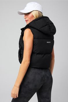 Essential Cropped Hooded Puffer Vest Fabletics black female Activewear >> Womens >> Jackets & Outerwear >> Jackets regular Everyday Hidden Pockets/Reflective/Water-Resistant Black Nylon Hooded Activewear, Black Hooded Nylon Activewear, Winter Athleisure Outerwear With Fleece Lining, Black Fitted Activewear For Winter, Winter Workout Activewear With Drawstring Hood, Sporty Puffer Jacket With Adjustable Hood For Sports, Stretch Winter Sports Outerwear, Black Stretch Functional Outerwear, High Stretch Outerwear For Sports In Fall