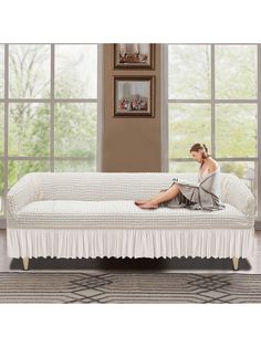 a woman sitting on top of a white couch