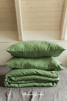 three green pillows stacked on top of each other