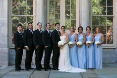 a group of people standing next to each other in front of a building with windows