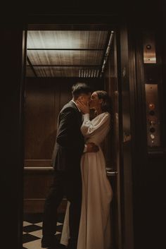 a bride and groom kissing in an elevator