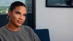 a close up of a person sitting in a chair with a large pair of earrings on her head