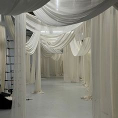 an empty room with white drapes covering the walls