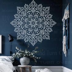 a bedroom with blue walls and a white flower wall decal on the wall next to a bed