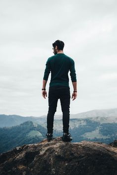 a man standing on top of a large rock