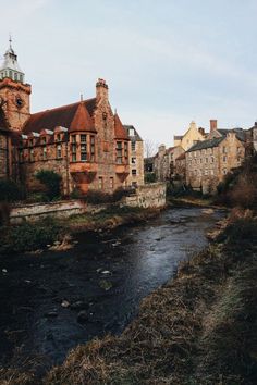 a river running through a city next to tall brick buildings on the side of a road