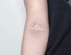 a woman's arm with a sunburst tattoo on the left side of her arm