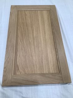 a wooden cutting board sitting on top of a white sheet