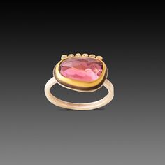 This remarkably sparkly, intriguing rose cut tourmaline in warm pink is wrapped in 22k gold and enhanced with a line of six tiny, brilliant diamonds. Setting, including diamond line, measures approximately 3/8 inch x 5/8 inch. Sterling silver back and 2mm hammered band. Matte finish.