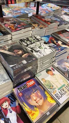 there are many dvds on the table for sale at this store and they are all stacked up together