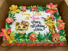 a birthday cake decorated with flowers and giraffes