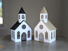 two paper houses that are sitting on a table