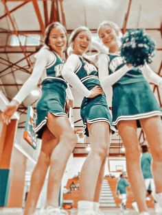 three cheerleaders are posing for a photo