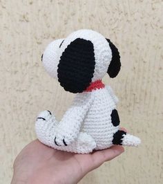 a hand holding a small crocheted stuffed dog