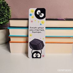 a bookmark with an image of two penguins wearing graduation caps on top of books