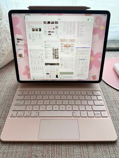 an open laptop computer sitting on top of a pink table next to a mouse and keyboard