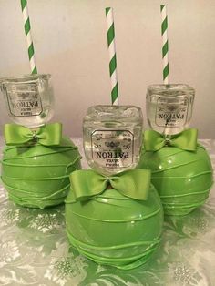 four green glass jars with candles in them