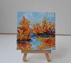 an easel with a painting on it sitting on a table