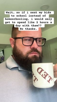 a man with glasses holding a coffee cup