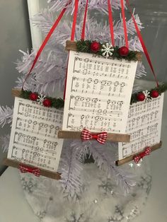 a christmas tree decorated with sheet music and red ribbon hanging from it's branches