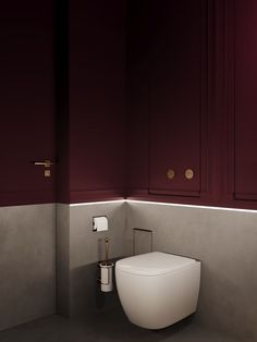 a white toilet sitting in a bathroom next to a wall mounted paper dispenser