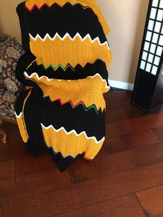 a large blanket sitting on top of a wooden floor next to a black and yellow chair