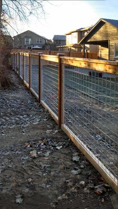 the fence is made of metal and wood with glass panels on each side, along with trash