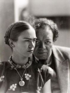 an old black and white photo of two people looking at something in front of them