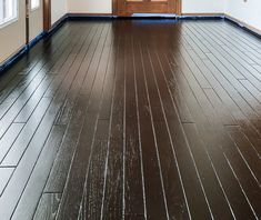 an empty room with wood floors and white walls