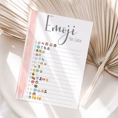 a notepad with emoji stickers on it sitting next to a fan