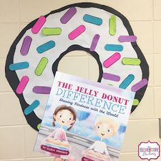 a person holding up a book in front of a donut shaped door hanger