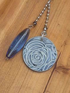 a necklace with a pendant that has a spiral design on it