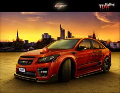 a red car parked in front of a city skyline