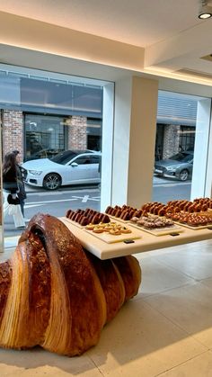 a table that has some food on it in the middle of a room with large windows