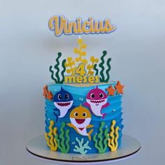 a birthday cake with two sharks on top and under the sea words above it that says, unique