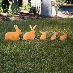 four plastic rabbits sitting in the grass